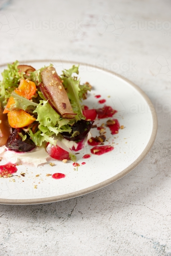 Close up - Plate of fresh salad of lettuce, beetroot, radish and stone fruit - Australian Stock Image