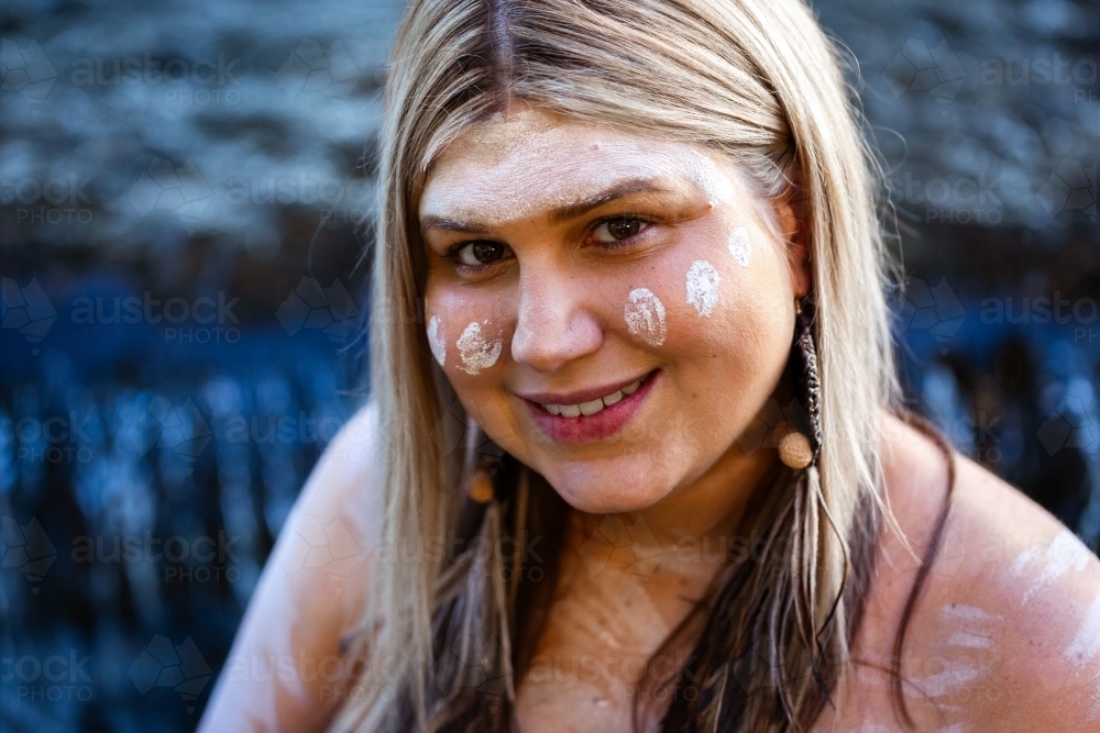 Close up portrait of first nations Australian woman with ochre paint - Australian Stock Image