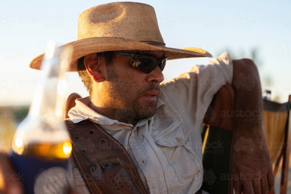 Close up shot of a man having a cold beer after a hard day mustering cattle - Australian Stock Image