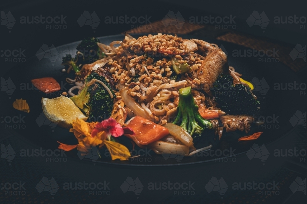 Close up shot of pad thai chicken in black plate - Australian Stock Image