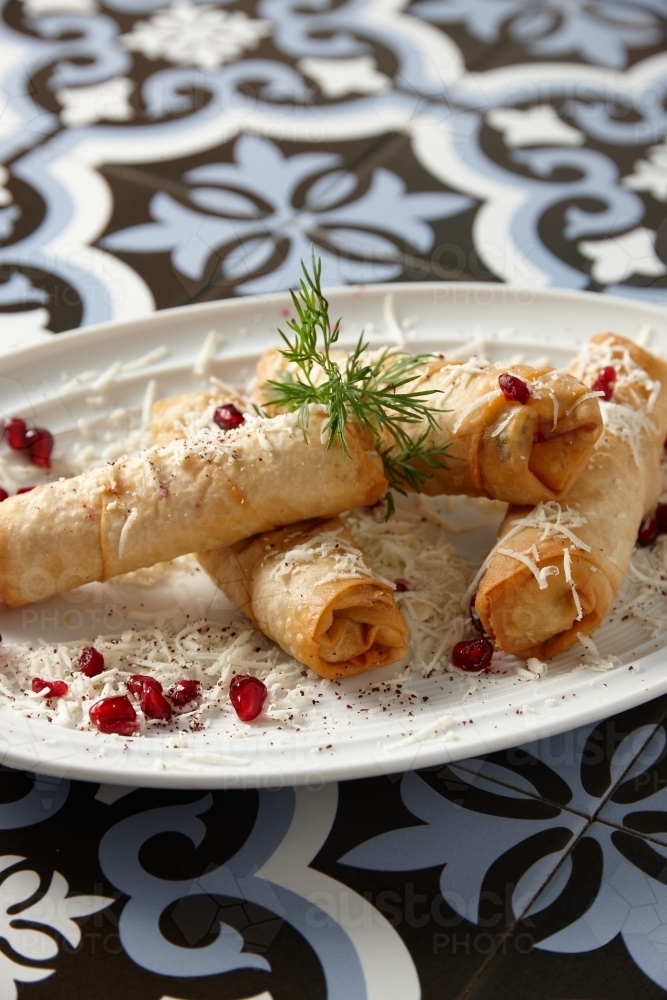 Close up shot with spring rolls sprinkled with shredded cheese - Australian Stock Image