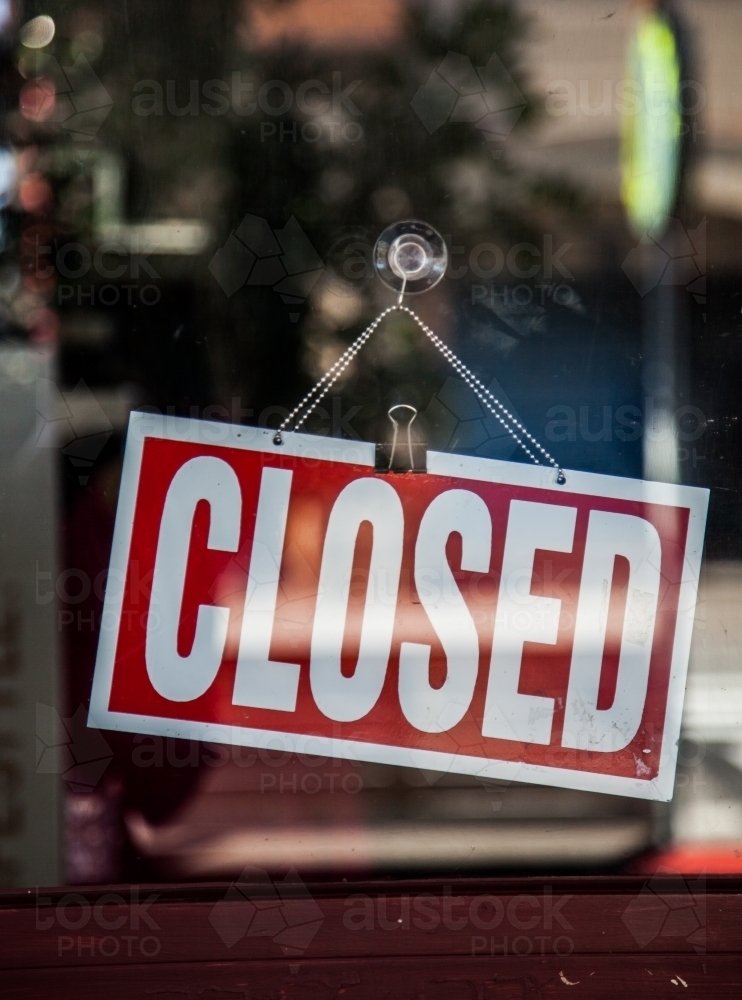 Image of Closed sign hanging in front window of shop - Austockphoto