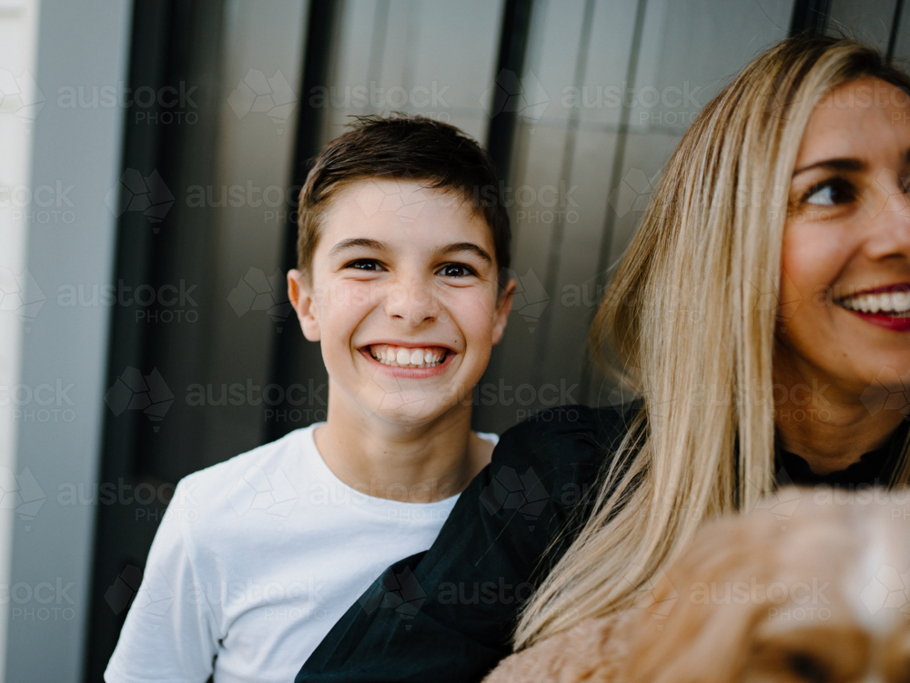 Closeup of a young boy smiling at the camera. - Australian Stock Image