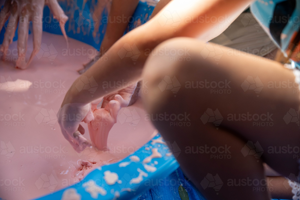 Closeup of children’s hands holding oobleck, cornstarch and water mixture, science experiment - Australian Stock Image