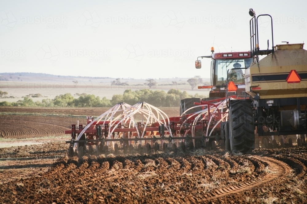 Closeup of tractor and seeder dry sowing crop in the Avon Valley, Western Australia - Australian Stock Image