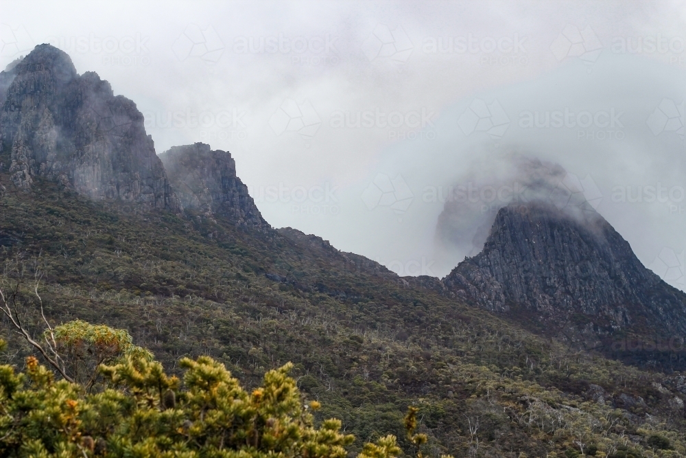 Cloud over steep mountain peaks, Cradle Mountain - Australian Stock Image