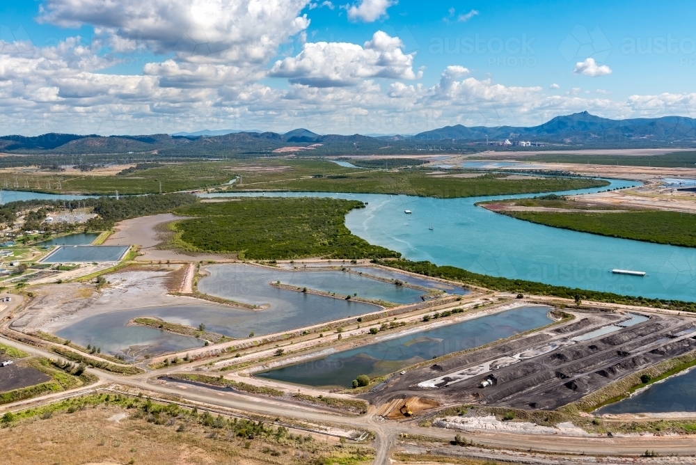 Coal sedimentation ponds, with Mount Larcom in the background, Gladstone, Queensland - Australian Stock Image