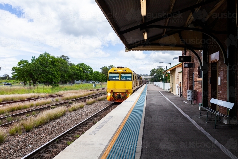 Coal train approaching railway station in Hunter Valley - Australian Stock Image