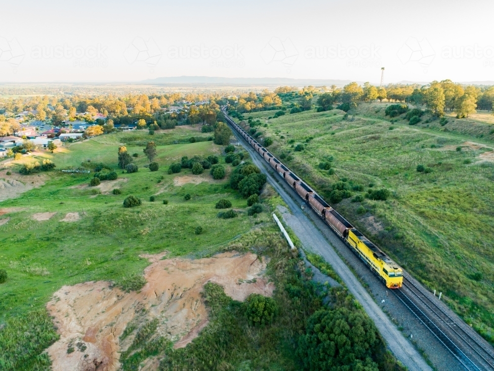 Coal train passing by on railroad at edge of Singleton, Hunter Valley - Australian Stock Image