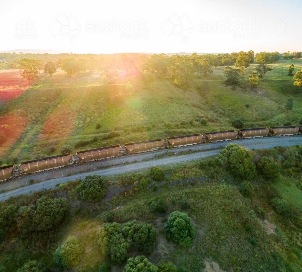 Coal train seen from drone on railway track through green landscape in Hunter Valley - Australian Stock Image