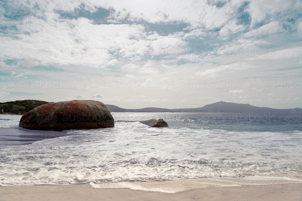 Coastal shot of beach with large rocks in water - Australian Stock Image