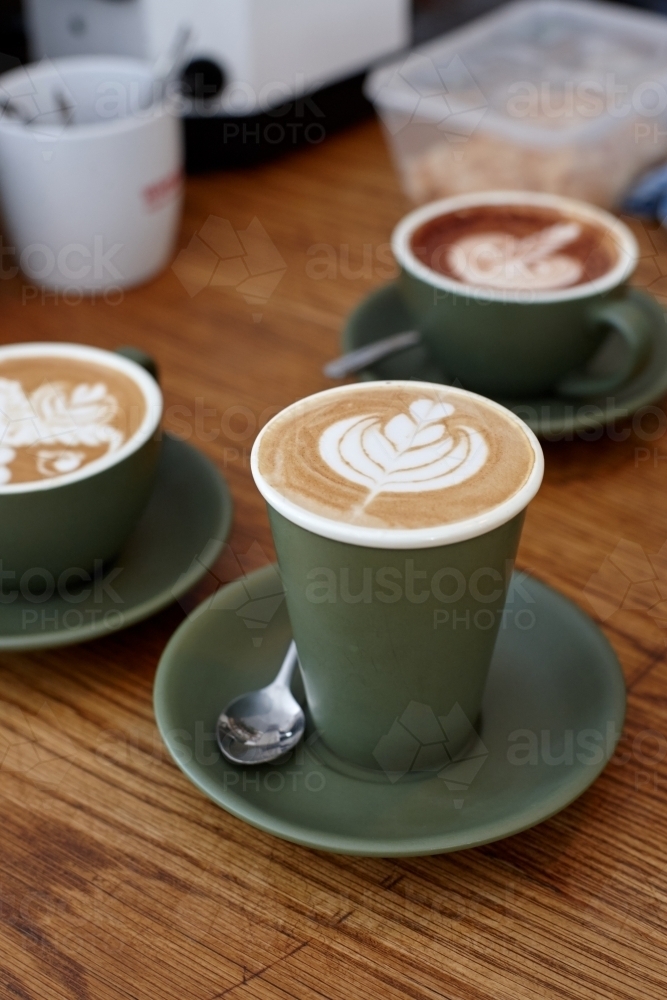 Coffee with froth decoration served on table - Australian Stock Image