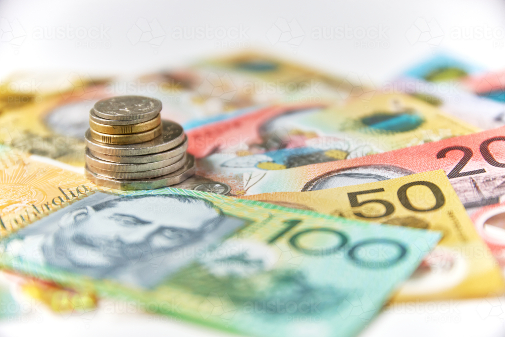 Collection of Australian banknotes and coins scattered on a flat surface - Australian Stock Image