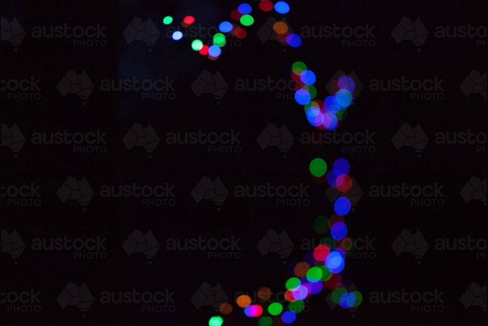 Coloured fairy lights on a black background - Australian Stock Image