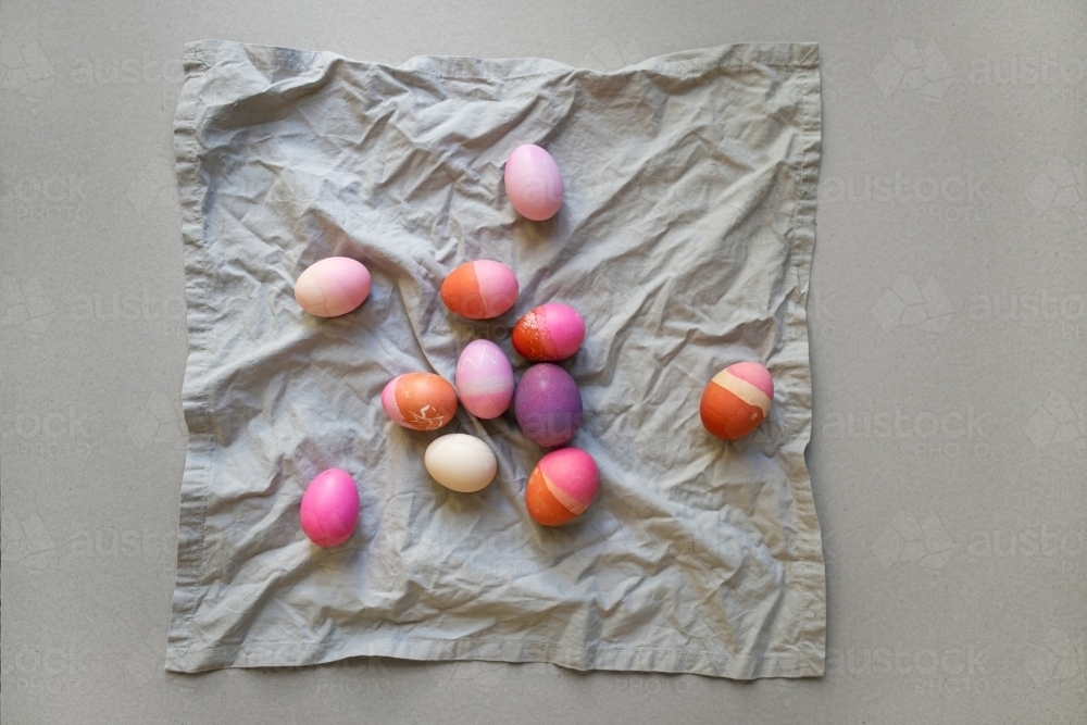 colourful Easter eggs on grey fabric - Australian Stock Image