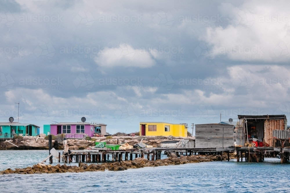 Colourful fishing shacks and sheds with an old wooden jetty for commercial crayfishing - Australian Stock Image