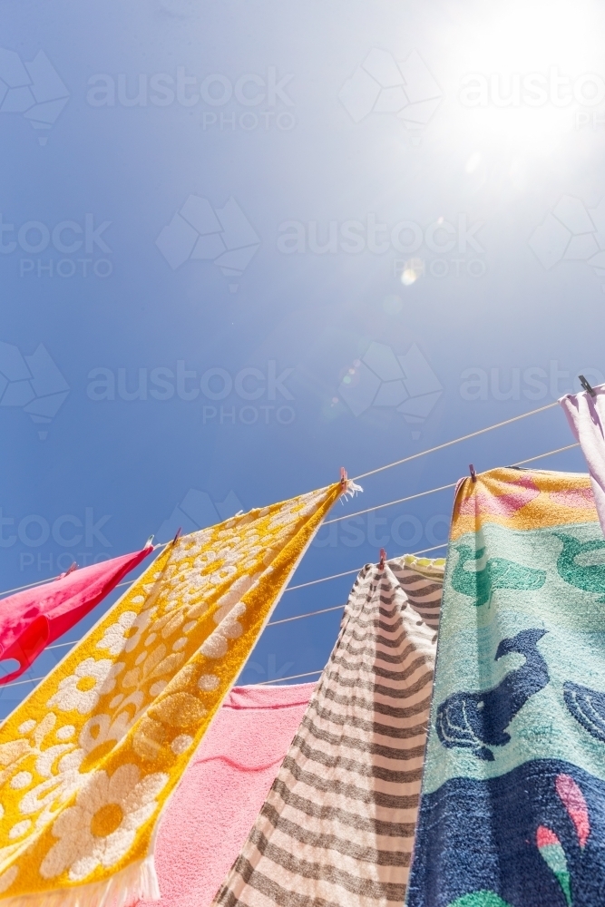 Colourful towels and swimmers hanging on washing line - Australian Stock Image