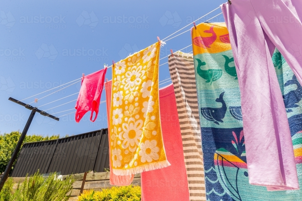 Colourful towels and swimmers hanging on washing line - Australian Stock Image