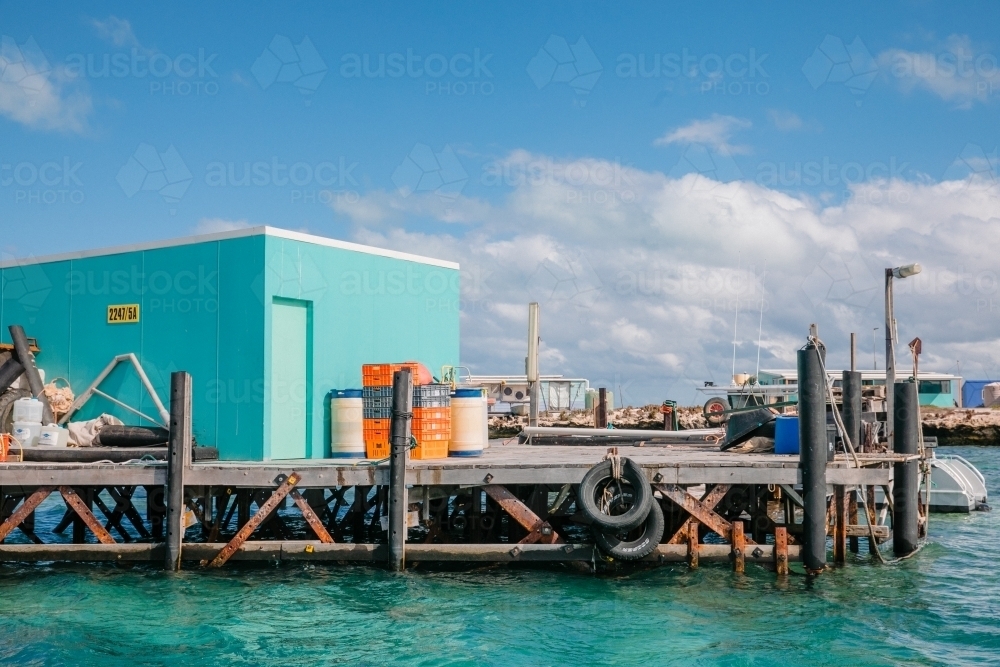 Commercial crayfishing jetty with bright coloured fishing shacks - Australian Stock Image