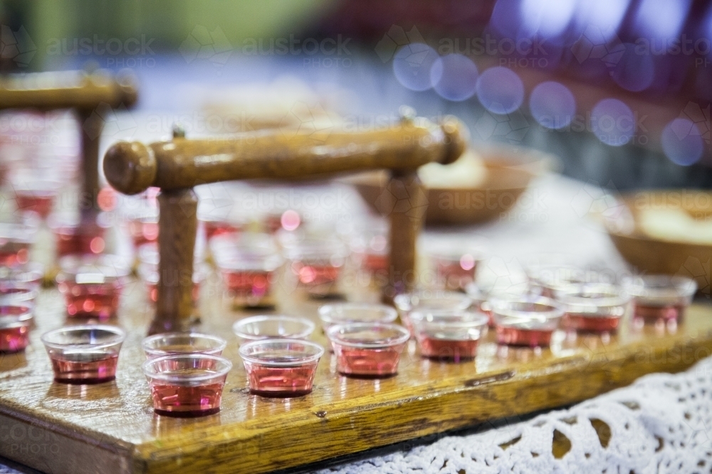 Communion cups of juice in trays and bread for a church service - Australian Stock Image