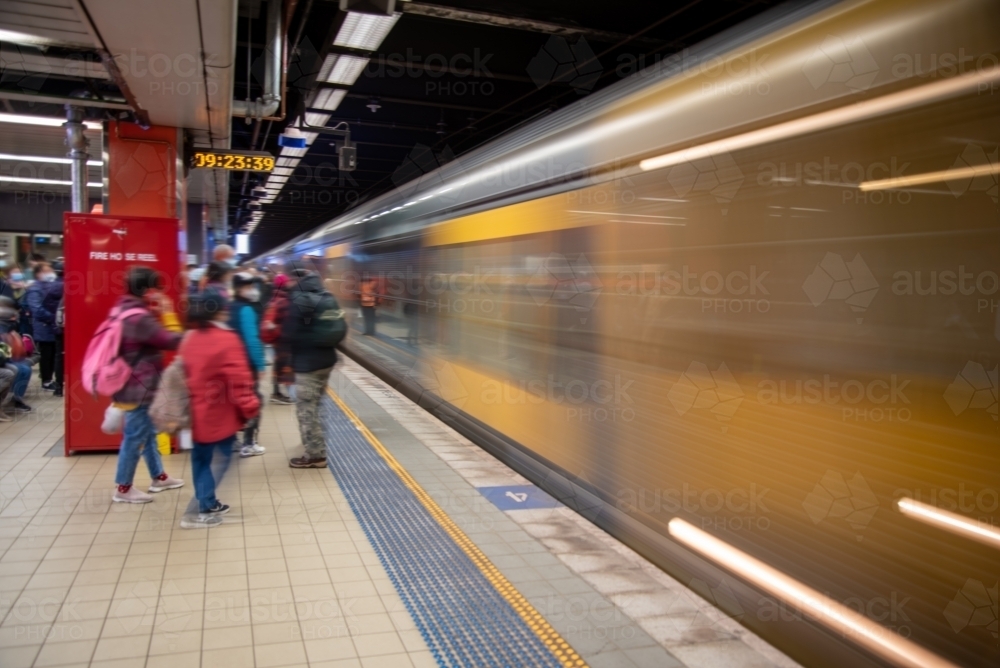 Commuters on the platform at Central Station in Sydney as a train goes past platform - Australian Stock Image