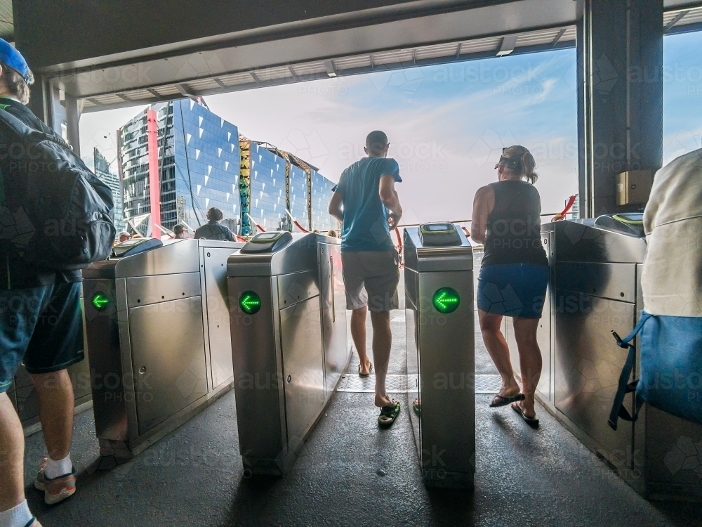 Commuters rushing through entrance barriers at a railway stations - Australian Stock Image