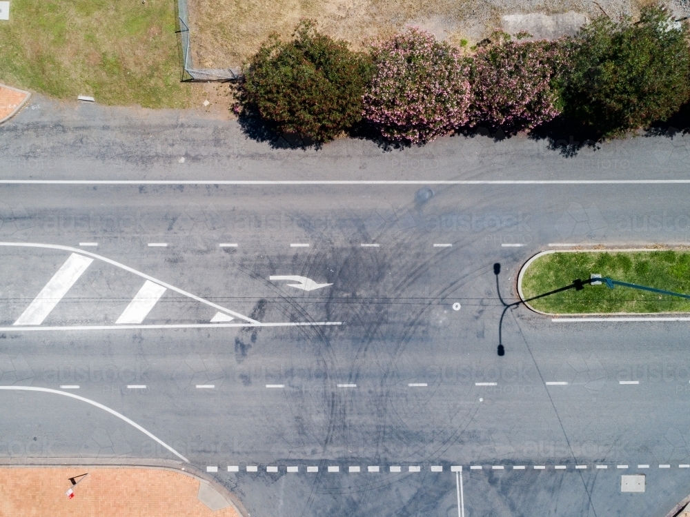 Complicated road markings with lanes and turning arrow at intersection from top down aerial angle - Australian Stock Image