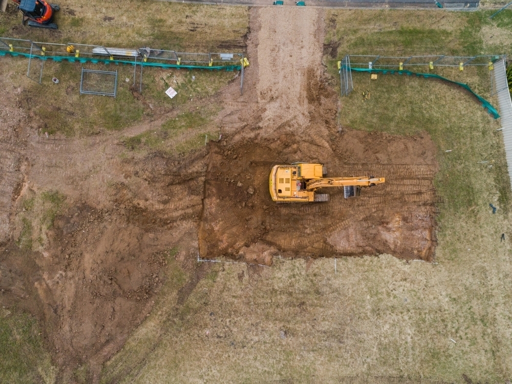 Construction site with digger levelling out ground for house build - Australian Stock Image