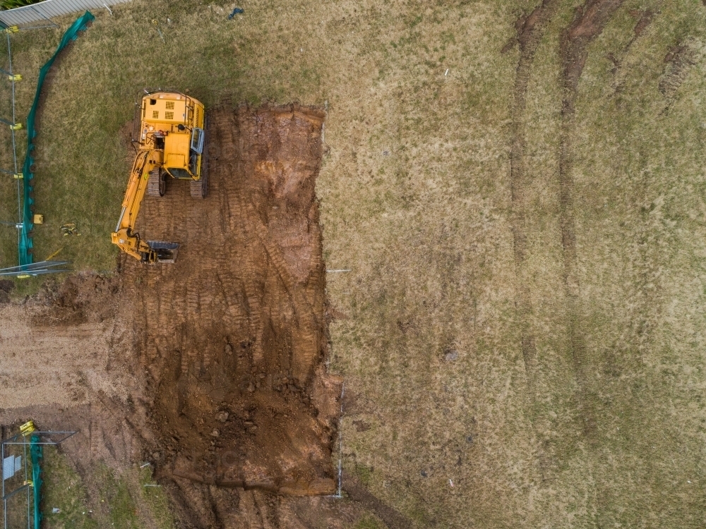 Construction site with digger levelling out ground for house build - Australian Stock Image