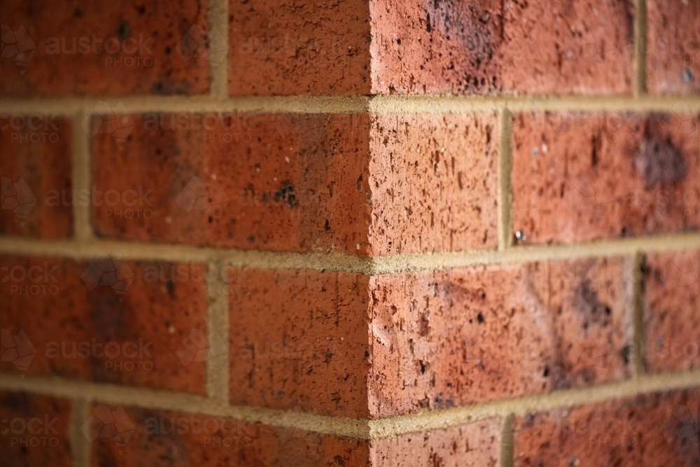 Corner of a red brick building, one light side and one dark side - Australian Stock Image