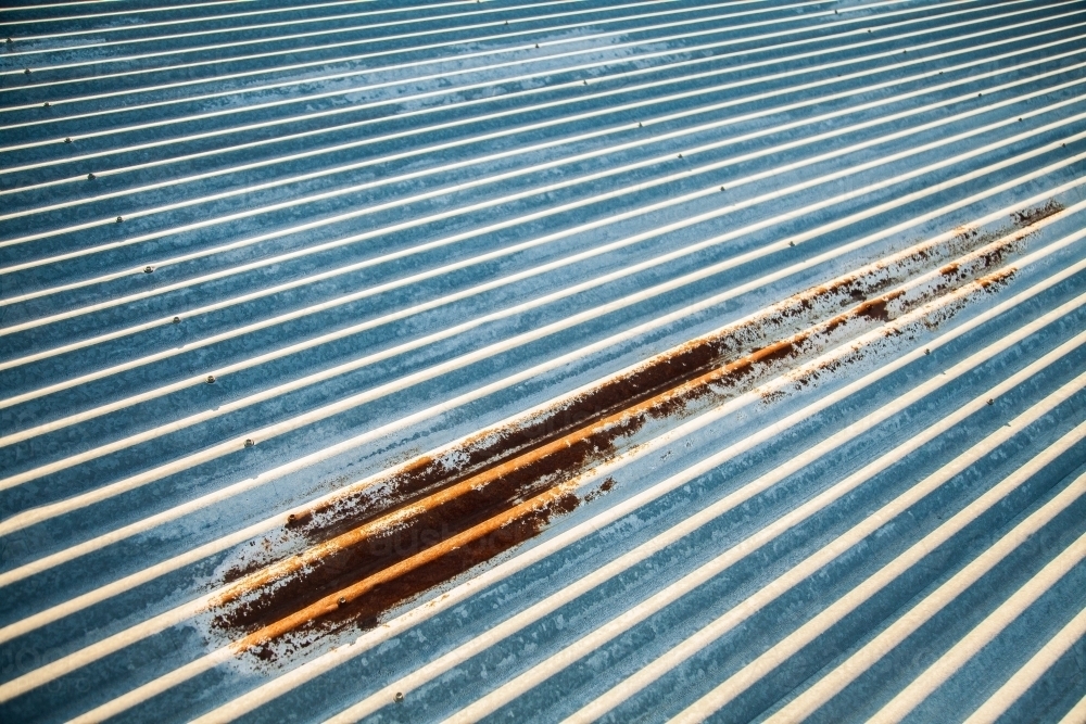 Corrugated iron roof with rusted patch - Australian Stock Image