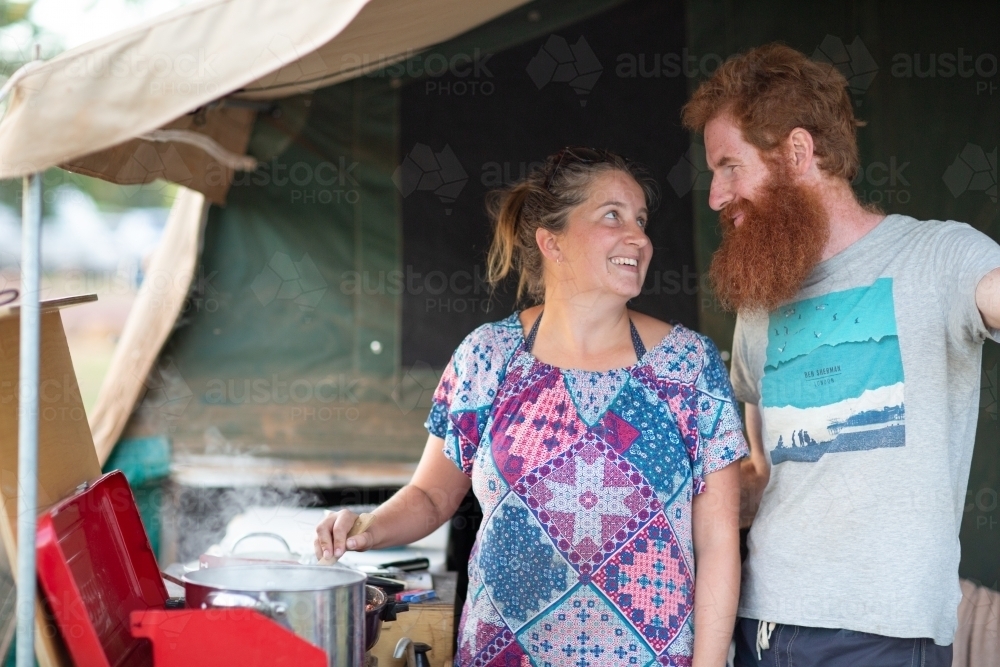 Couple cooking in the annex of their camper - Australian Stock Image