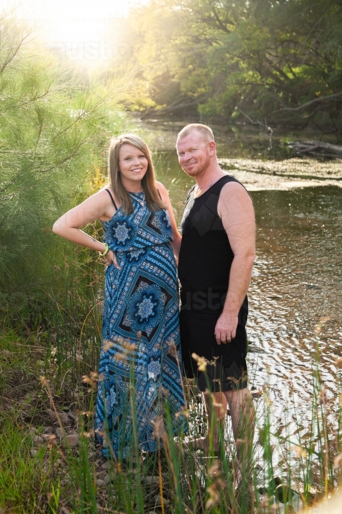 Couple standing together at riverside - Australian Stock Image