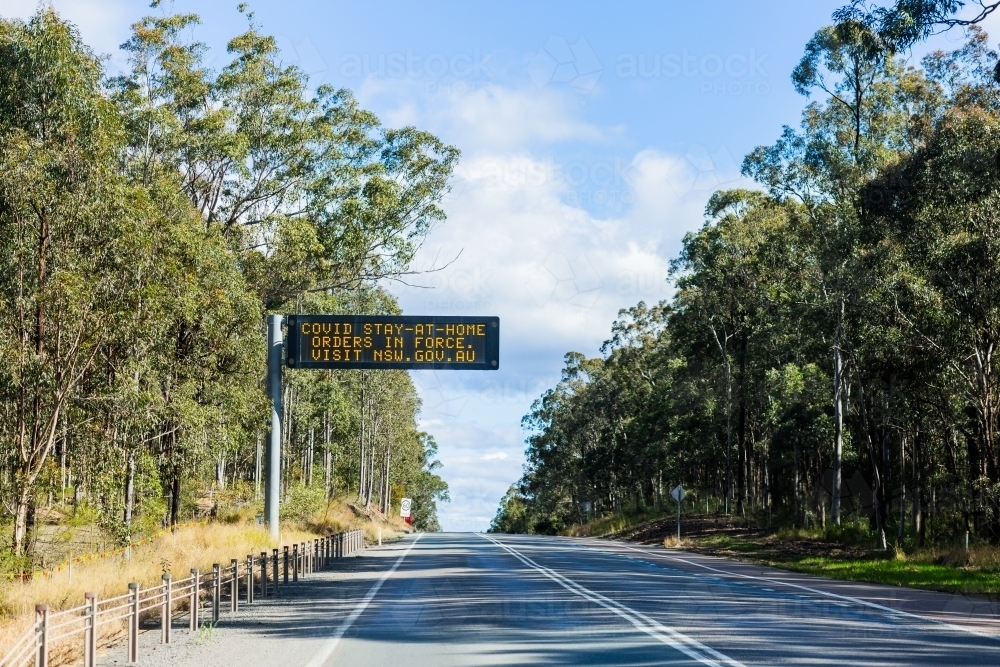 covid stay at home orders in force overhead sign on highway in NSW - Australian Stock Image