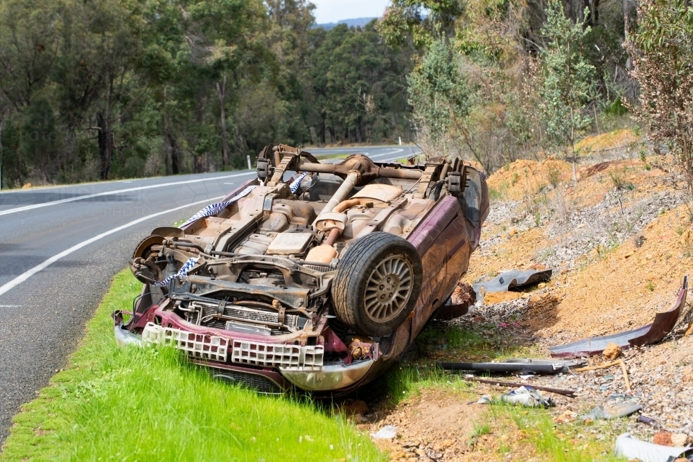 Crashed car upside down on side of country road - Australian Stock Image