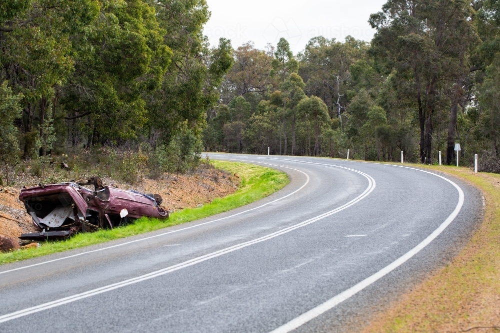 Crashed car upside down on side of country road - Australian Stock Image