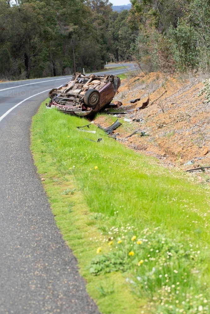 Crashed vehicle upside down on side of highway - Australian Stock Image