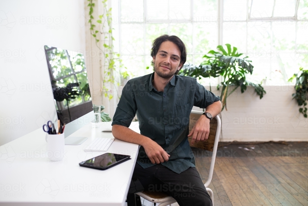 Creative business man looking at camera in studio environment - Australian Stock Image