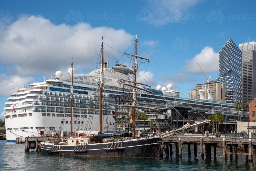 Cruise ship dwarfs older sailing ship in Circular Quay, Sydney - Australian Stock Image