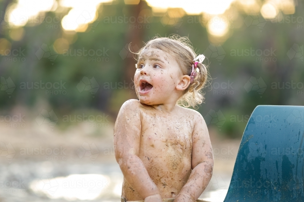 Cute little girl playing in mud - Australian Stock Image