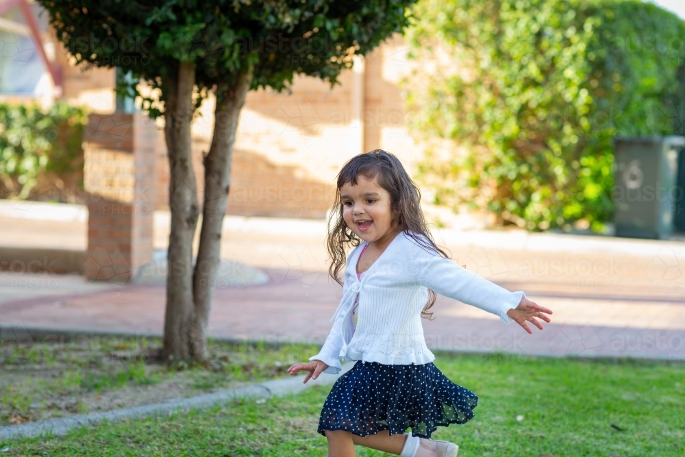 Cute little girl twirling around outside - Australian Stock Image