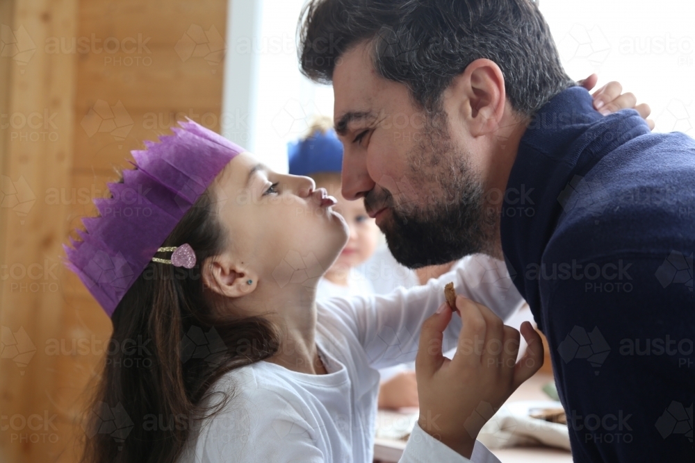 Dad and daughter showing affection wearing Christmas hat - Australian Stock Image