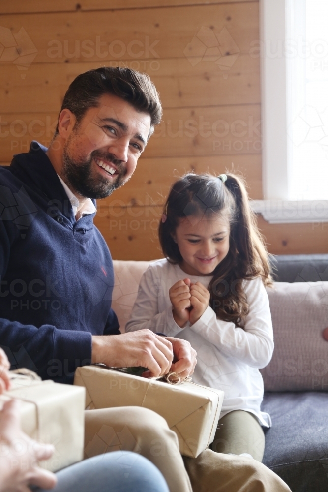 Dad and daughter unwrapping present - Australian Stock Image