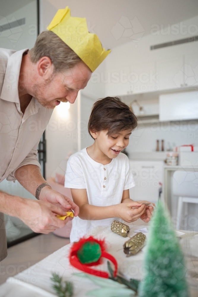 Dad and son looking inside Christmas bon-bon together - Australian Stock Image