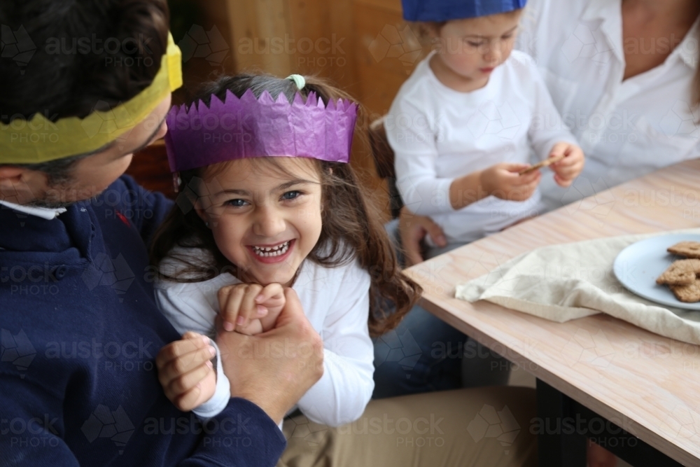 Dad holding daughter wearing Christmas hats - Australian Stock Image