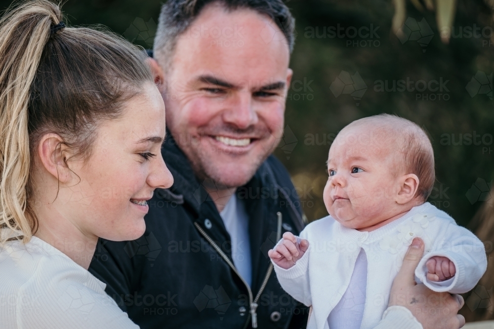 Dad smiles with his two daughters. - Australian Stock Image