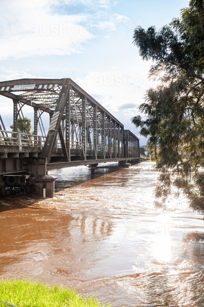 Dangerous flood water rising up bridge pylons after rain - Australian Stock Image