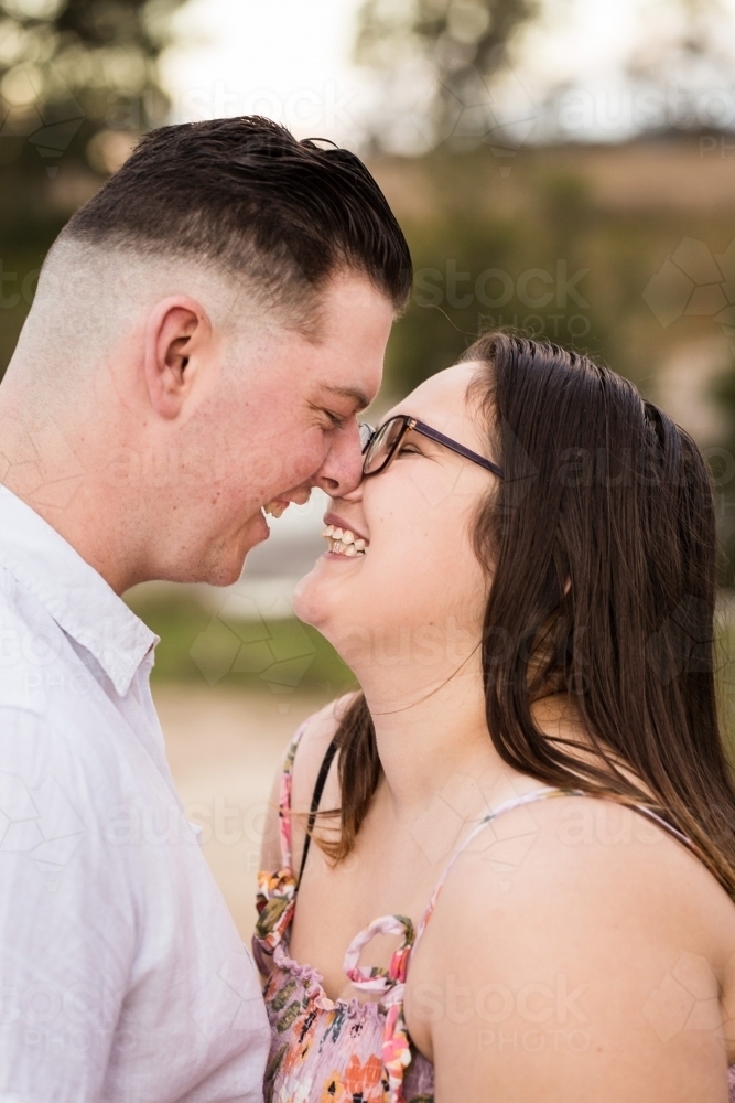 Dating couple rubbing noses close together laughing - Australian Stock Image