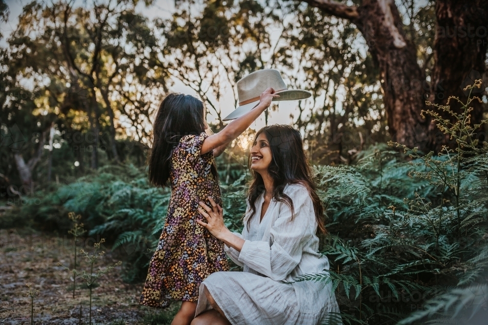 Daughter putting a hat on mother - Australian Stock Image