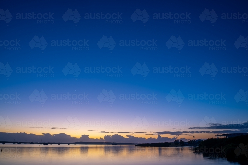 Dawn sky over water with clouds - Australian Stock Image